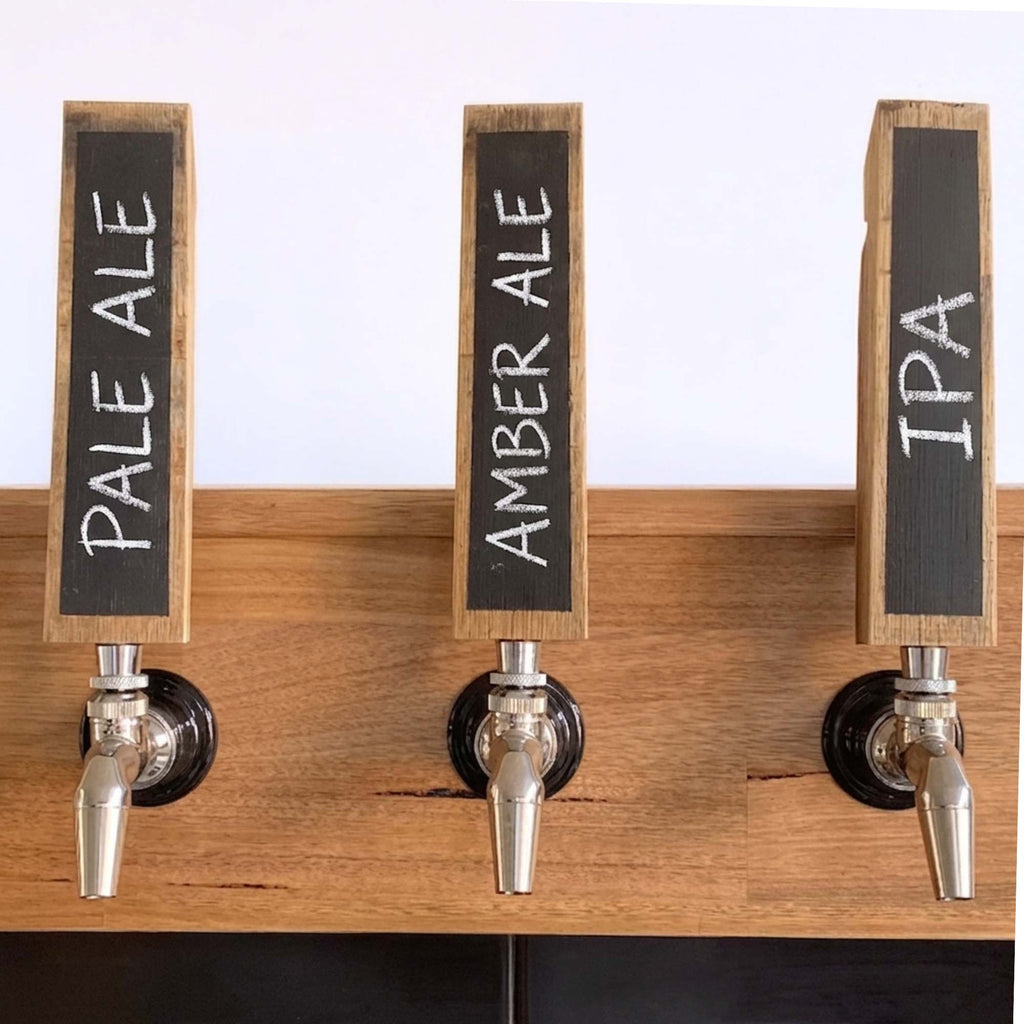 Three reclaimed oak barrel stave tap handles with chalkboard faces labelled with different brew names