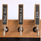 Three reclaimed oak barrel stave tap handles with chalkboard faces labelled with different brew names