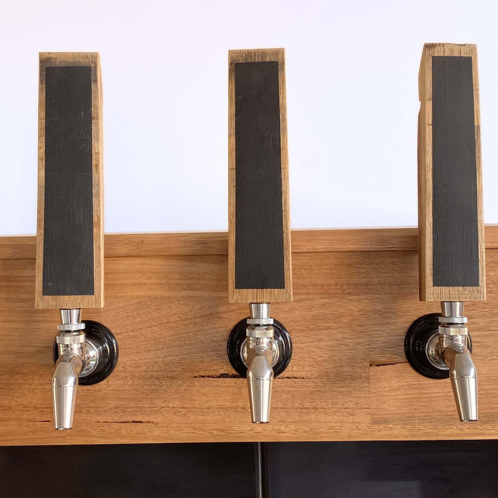 Three barrel stave chalkboard tap handles installed on a home keezer kegerator