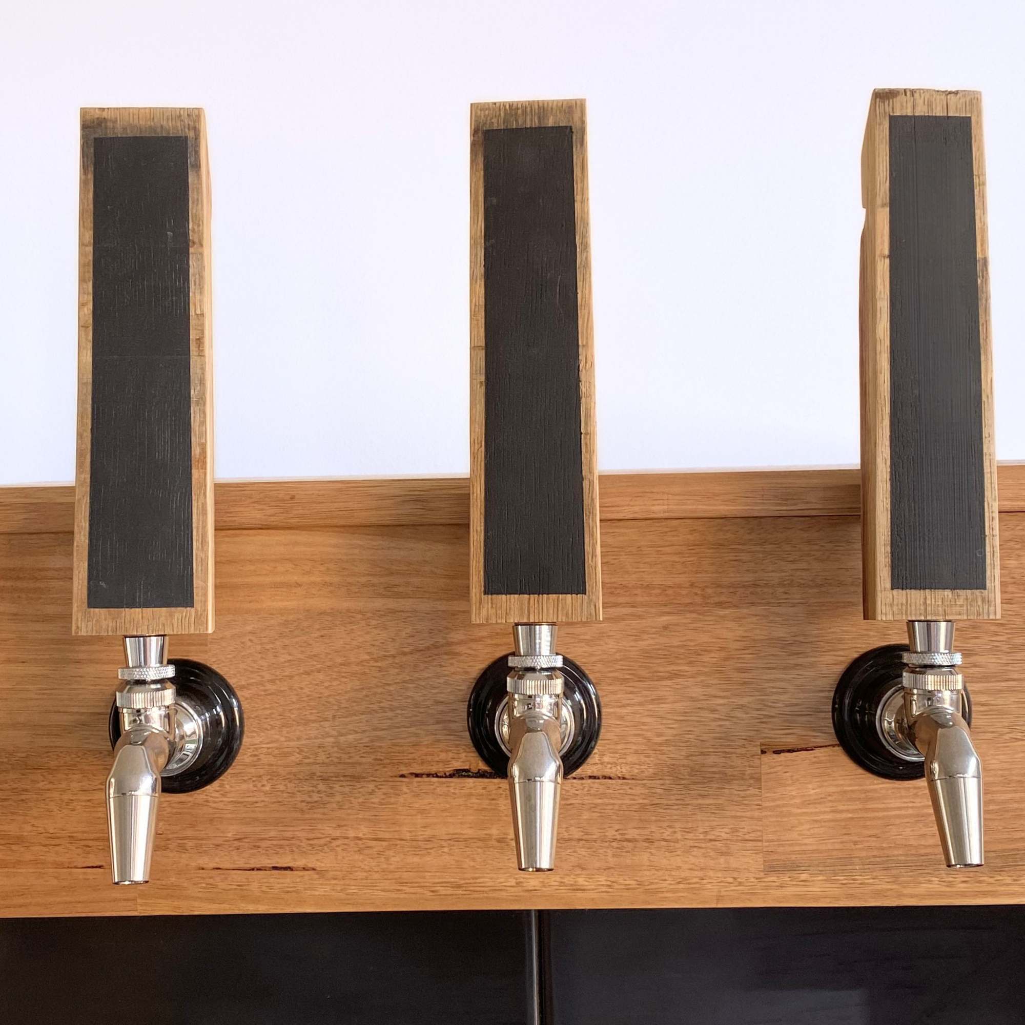 Three barrel stave chalkboard tap handles installed on a home keezer kegerator