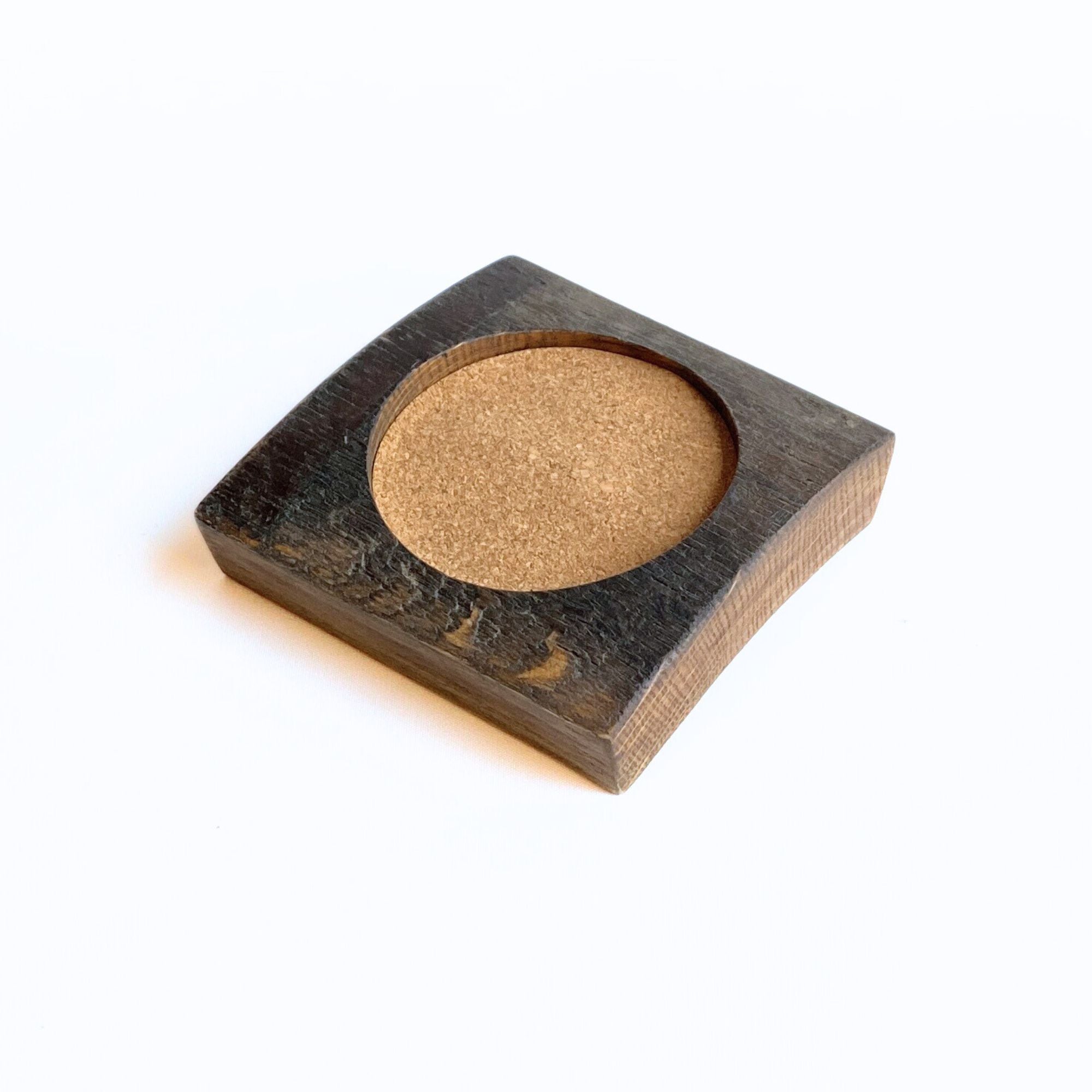 Square wooden barrel stave coaster with a round cork insert on a white background