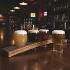 Barrel stave beer flight with 4 glasses of various beers in a bar setting