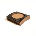 Rustic oak barrel stave coaster with cork inset on a white background