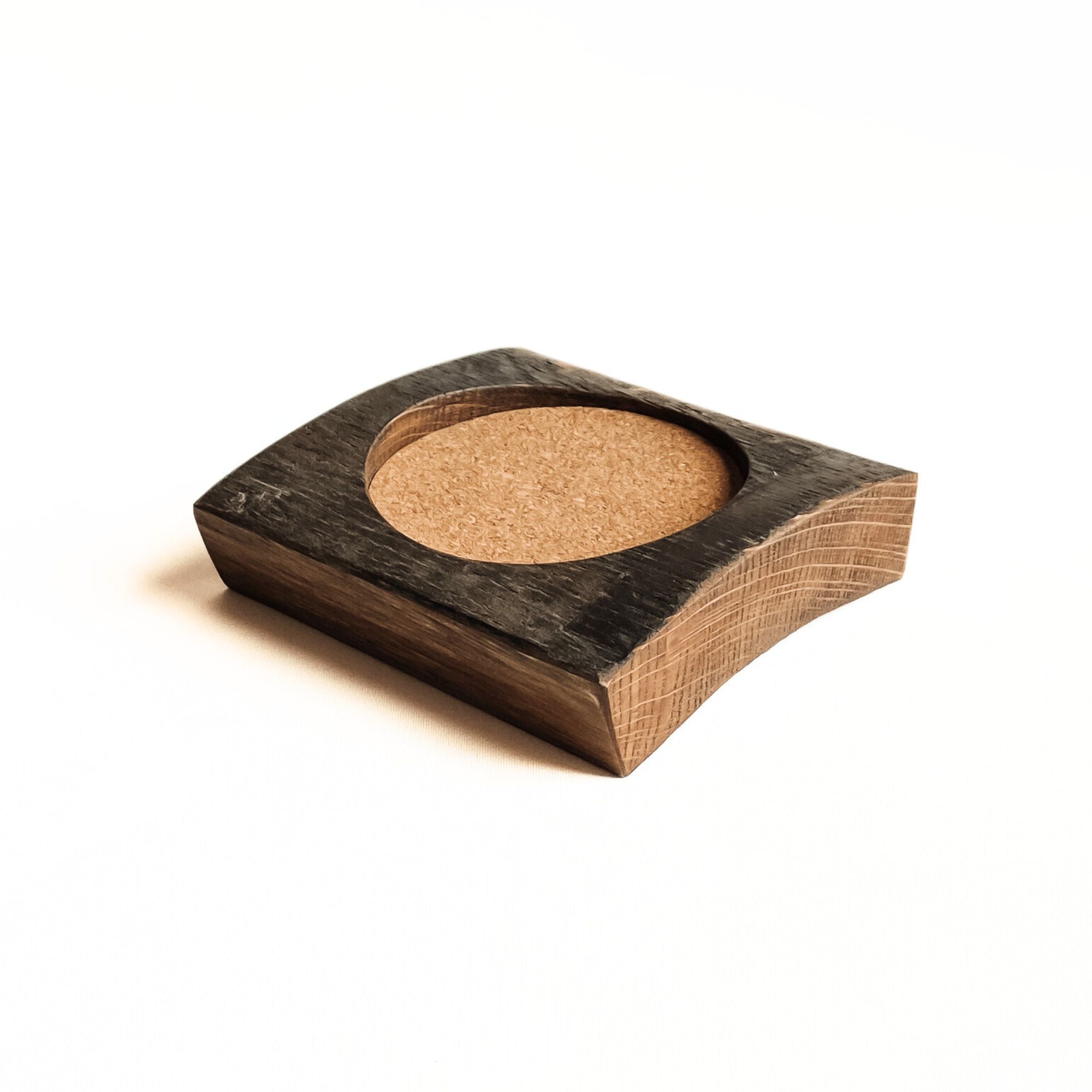 Rustic oak barrel stave coaster with cork inset on a white background