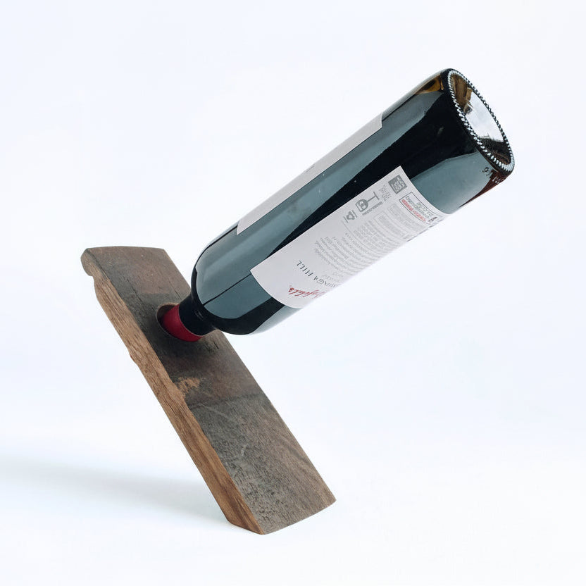 Barrel stave floating wine bottle holder with a red wine bottle on a white background, 3/4 view