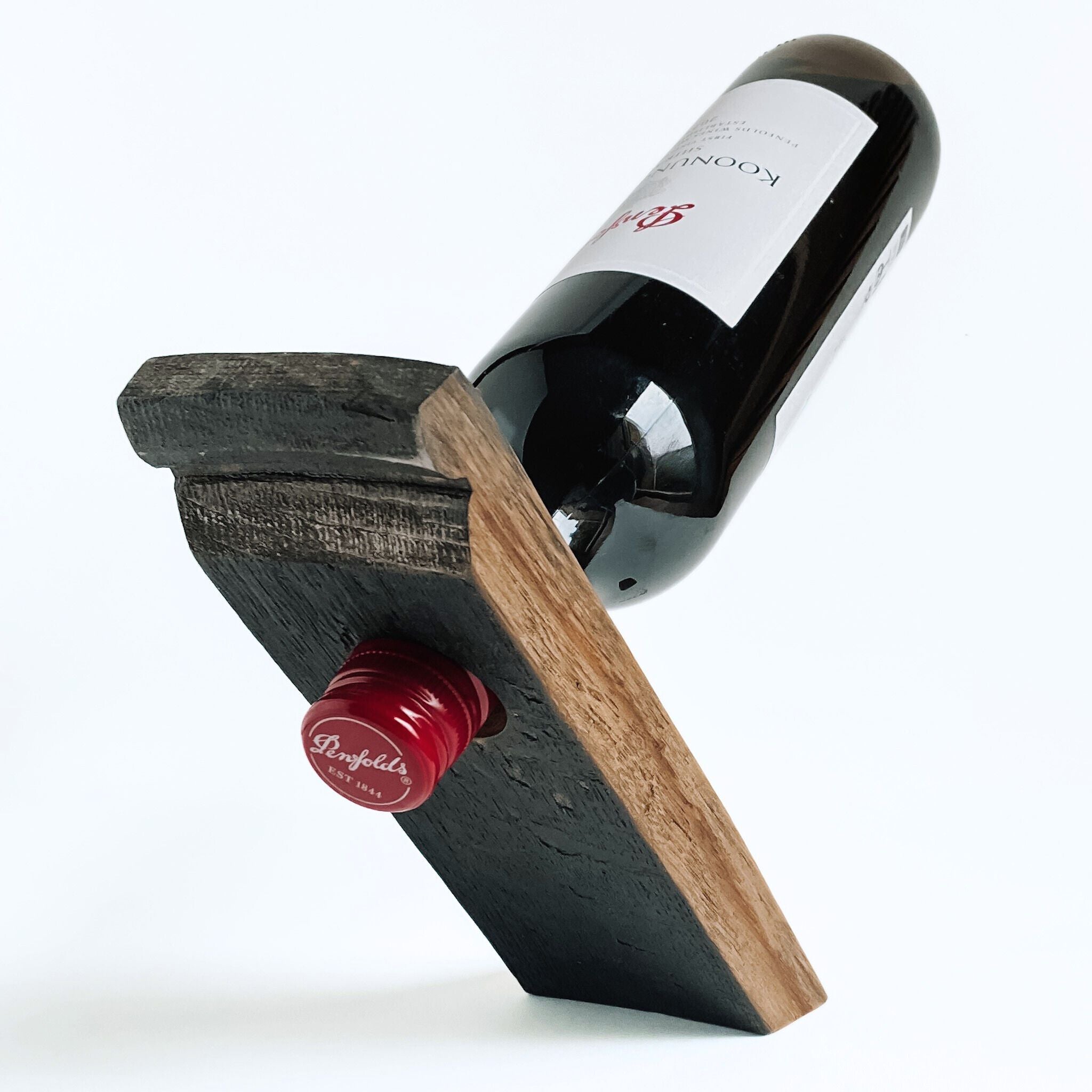 Barrel stave floating wine bottle holder with a red wine bottle on a white background, back view