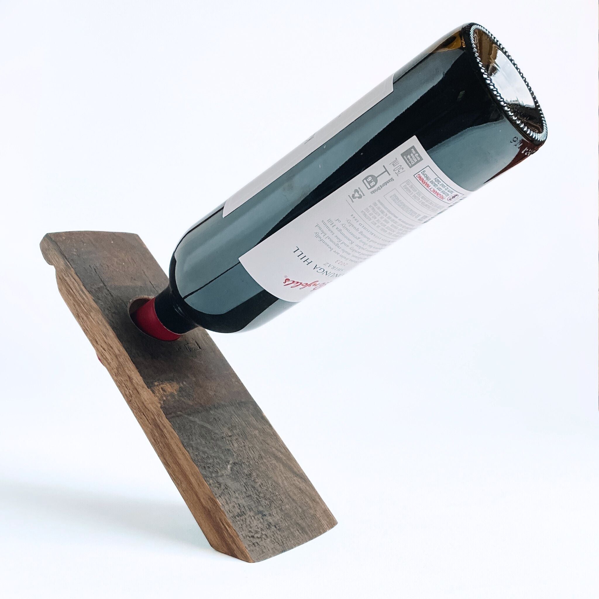 Barrel stave floating wine bottle holder with a red wine bottle on a white background, 3/4 view
