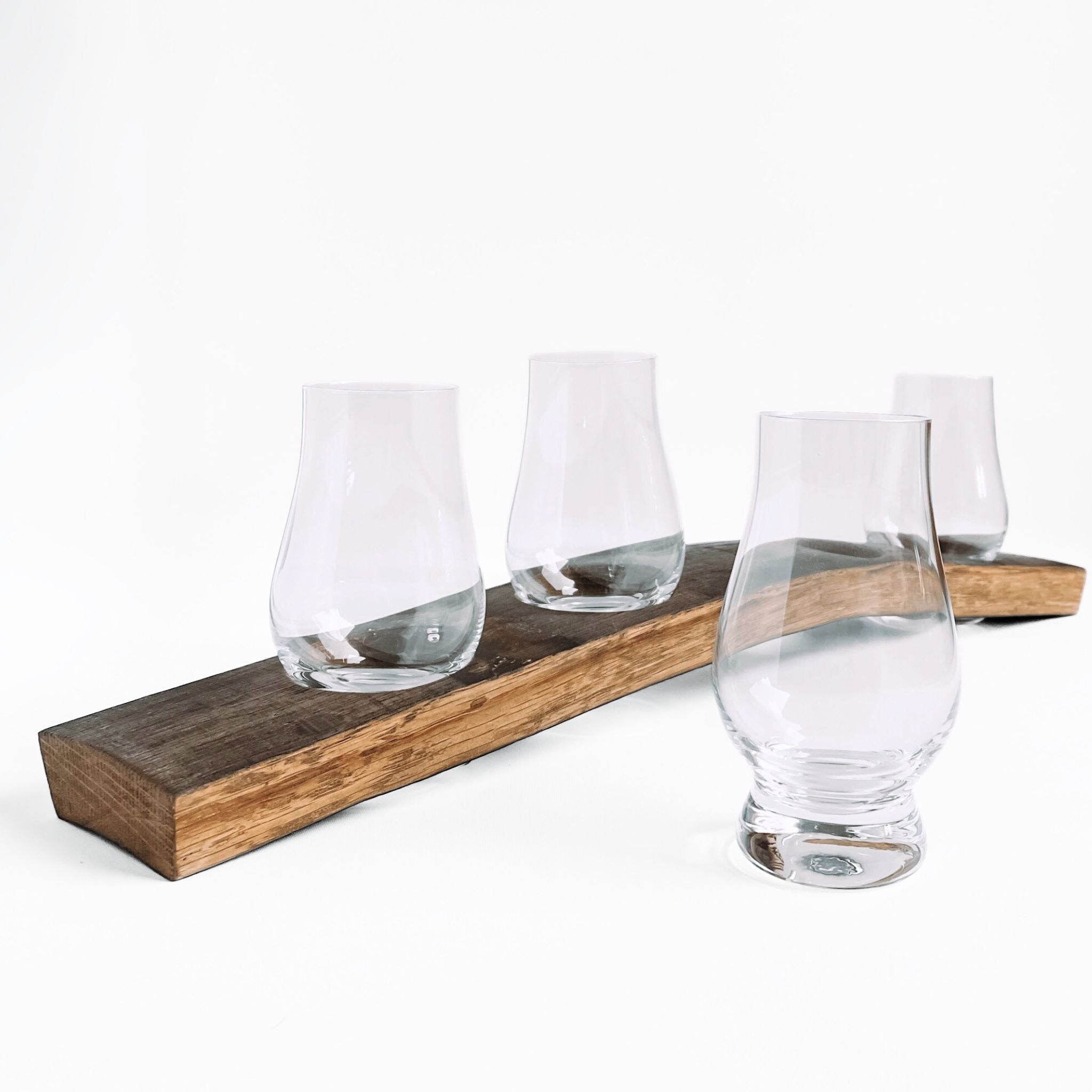 Barrel Stave whiskey flight tasting board with 4 Glencairn whiskey glasses, one glass in front of board