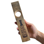 Hand holding engraved wine bottle holder - save water drink wine design.  Front view
